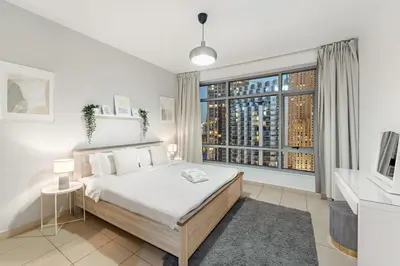 a bedroom with a bed and a large window at FIRST CLASS 2BR Elegant Urban Retreat in Dubai