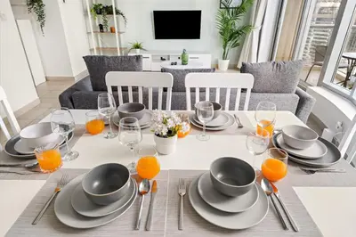 a dining room with a table with plates and glasses at FIRST CLASS 2BR Elegant Urban Retreat in Dubai