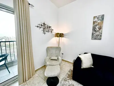 a living room with a chair and a couch at Chic 1BR with the City Views in Dubai