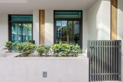 a building with potted plants in front of windows at Livbnb - Stylish Studio in JVC, Near Parks and Shops in Dubai