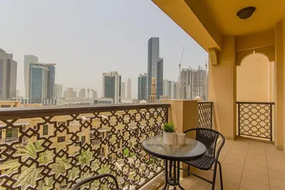 a balcony with a table and chairs and a city skyline at Cozy 1BR Apart Downtown Burj Khalifa and Dubai Mall in Dubai