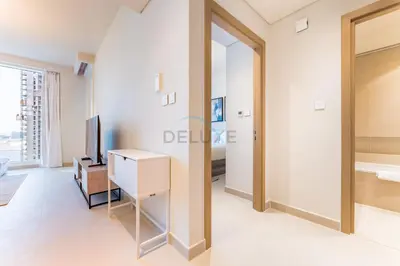 a living room with a television and a desk at High-Rise 1BR with Stunning Creek Views,Near to Dubai Creek Tower Viewpoint, Harbour Gate Tower 2, Dubai Creek Harbour by Deluxe Holiday Homes in Dubai