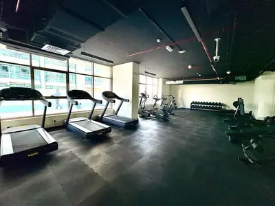 a gym with several treadmills in a room at FIRST CLASS 2BR Sleek Urban Oasis in Dubai