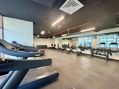 a gym with rows of treadmills and benches at FIRST CLASS 2BR Sleek Urban Oasis in Dubai