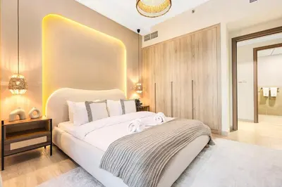 a bedroom with a large white bed in a room at FIRST CLASS 2BR Sleek Urban Oasis in Dubai