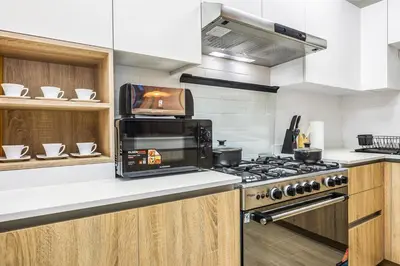 a kitchen with a stove and a microwave at FIRST CLASS 2BR Sleek Urban Oasis in Dubai