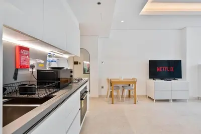 a kitchen with a counter and a table in it at Vibrant&Chic - Studio - 6MN Dubai Mall - Pool&Gym in Dubai