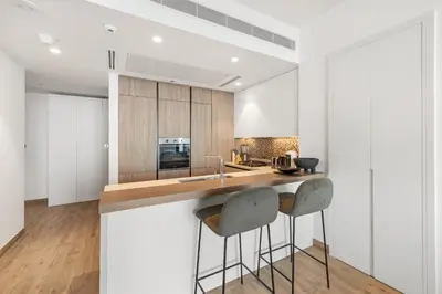 a kitchen with white walls and a counter with stools at 1BR Jumeirah Living - Marina View - 5 STARS Facilities in Dubai