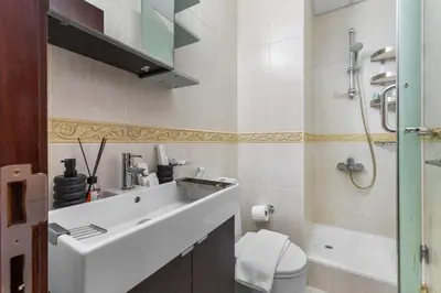 a bathroom with a white sink and a toilet at Stylish 2BR in Elite Tower with Bluewaters View and JBR in Dubai