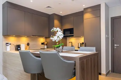 a kitchen with a table with chairs and a counter top at WOW Port de la Mer Skyline Blick Dubai in Dubai