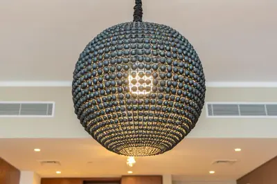 a large ball chandelier hanging from a ceiling at WOW Port de la Mer Skyline Blick Dubai in Dubai