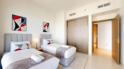 two beds in a hotel room with white walls at Grand Bleu 2 - Sophisticated Two Bed with Sea View in Dubai