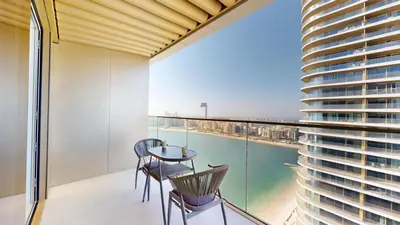 a balcony with a table and chairs and a view of the city at Grand Bleu 2 - Sophisticated Two Bed with Sea View in Dubai