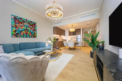 a living room with a blue couch and a tv at La Mer 1BR Ocean View 4 Pax in Dubai