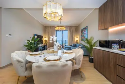 a dining room with a table and chairs and a kitchen at La Mer 1BR Ocean View 4 Pax in Dubai
