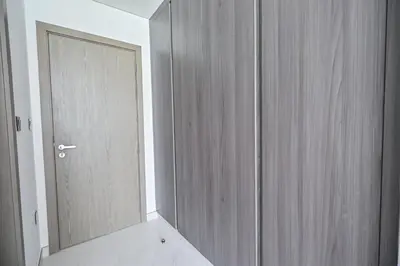 a bathroom with a mirror next to a door at Chic 2BR Heart of District One in Dubai