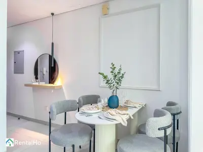 a white dining room with a table and chairs at Amazing New Design Flat with Rooftop Pool in Dubai Marina 5 pax in Dubai