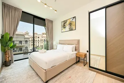 a bedroom with a bed and a large window at Stunning 1 br modern luxury residence at JVC in Dubai