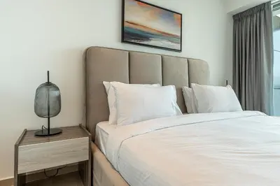 a bedroom with a bed and a lamp on a night stand at HAVN - Upgraded 1 Bed in 8 Boulevard Walk Downtown in Dubai