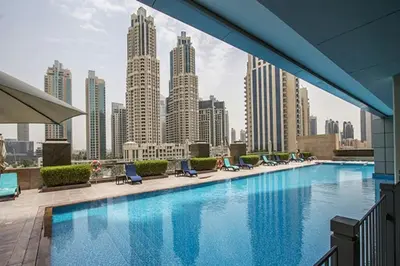a large swimming pool with a view of a city at HAVN - Upgraded 1 Bed in 8 Boulevard Walk Downtown in Dubai
