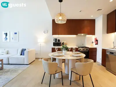 a kitchen and living room with a table and chairs at HiGuests - Seaside Serenity 1 BR at Port De La Mer in Dubai