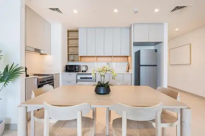 a kitchen and dining room with a wooden table and chairs at Brand New Creek Home with Panoramic Water View in Dubai