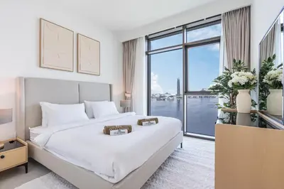 a white bedroom with a large bed and a large window at Brand New Creek Home with Panoramic Water View in Dubai