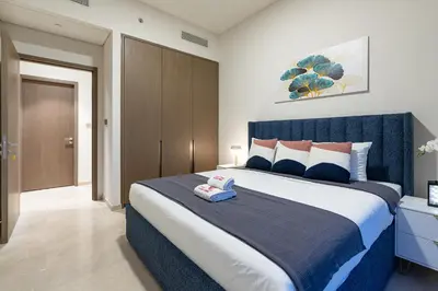 a bedroom with a large bed with a blue headboard at Full Burj Khalifa and Fountain View from All Rooms in Dubai