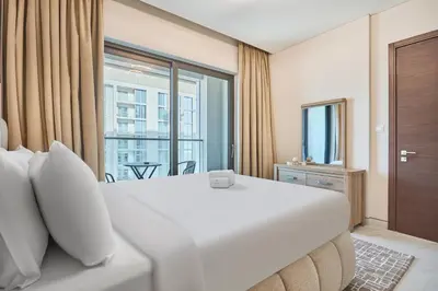 a bedroom with a large white bed and a window at STAY BY LATINEM Luxury 1BR Holiday Home CVG 3204 Near Burj Khalifa in Dubai