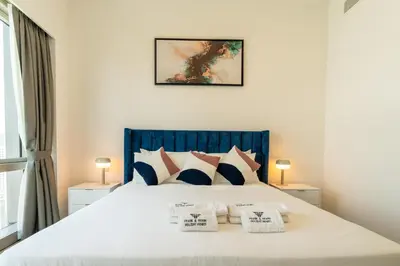 a bedroom with a large white bed with three pillows at Burj & Fountain View Retreat in Dubai
