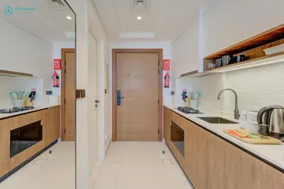 a kitchen with a door leading to a hallway at Bright & Luxury Studio with Balcony in Al Furjan in Dubai
