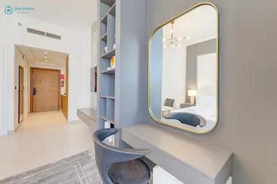 a mirror on a wall with a chair in a room at Bright & Luxury Studio with Balcony in Al Furjan in Dubai