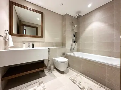 a bathroom with a sink and a tub and a toilet at Seaside Elegance 1BR Luxury Apartment with Private Beach Access, Emaar Beachfront in Dubai