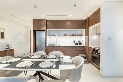 a kitchen and dining room with a table and chairs at ALiving Classy 1BR I Stunning Views I Emaar Palace Beach Residence in Dubai