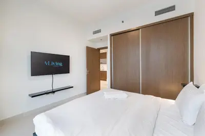 a bedroom with a bed with a tv on the wall at ALiving Classy 1BR I Stunning Views I Emaar Palace Beach Residence in Dubai