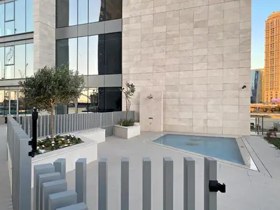 a building with a swimming pool in front of a building at 2BR Canal Front B3, Waterfront Views in Dubai