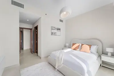 a white bedroom with a white bed with pillows at 2BR Canal Front B3, Canal Views in Dubai