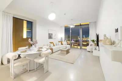 a white living room with a white table and chairs at 2BR Canal Front B3, Canal Views in Dubai