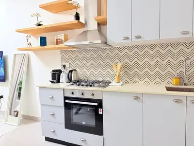 a kitchen with white cabinets and a stove top oven at One bedroom Full view Dubai Hills in Dubai