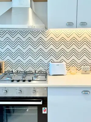 a kitchen with a stove and a checkered wall at One bedroom Full view Dubai Hills in Dubai