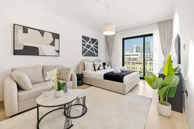 a white living room with a bed and a couch at Holiday Boulevard - Stylish Upgraded Studio - Designer Touches in JVC in Dubai