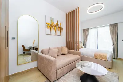 a bedroom with a bed and a couch and a mirror at Elegant JVC Stay Luxury Amid Nature in Dubai