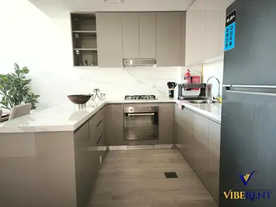 a kitchen with white cabinets and a counter top at 2BR Sofa Bed Sleep 6 Furjan in Dubai