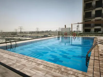 a large swimming pool on top of a building at 2BR Sofa Bed Sleep 6 Furjan in Dubai