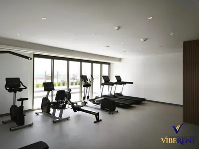 a gym with treadmills and exercise bikes in a room at 2BR Sofa Bed Sleep 6 Furjan in Dubai