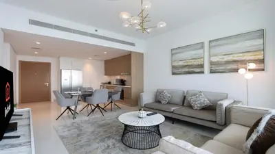 a living room with a couch and a table at Luxury 2BR, Panoramic Sea Views and Beach Access in Dubai