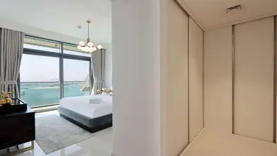 a bedroom with a bed and a large window at Luxury 2BR, Panoramic Sea Views and Beach Access in Dubai