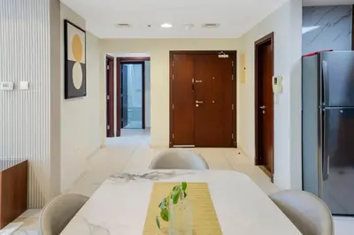 a dining room with a table and chairs and a refrigerator at 13P-Sea View Apartment in Dubai Marina with Pool & Balcony in Dubai