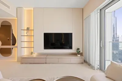 a living room with a flat screen tv on a wall at Elite Escapes - 2 BHK Luxurious - Grande Signature in Dubai