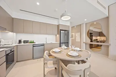 a kitchen and dining room with a table and chairs at Elite Escapes - 2 BHK Luxurious - Grande Signature in Dubai
